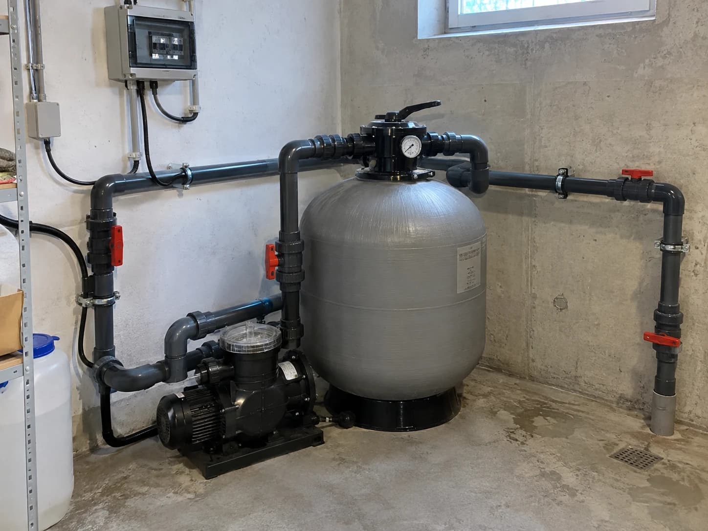 Pool-Technikraum mit Sandfilter, Umwälzpumpe und sichtbaren Leitungen
