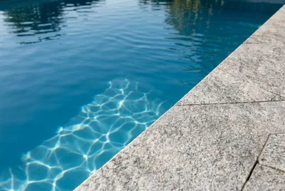 Sonnenlicht auf klarem Poolwasser, KI-Symbolbild
